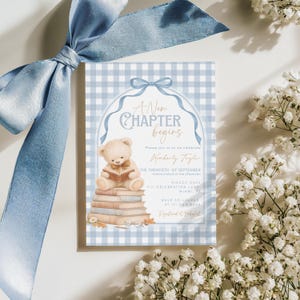 May include: A baby shower invitation with a blue gingham background and a teddy bear reading a book. The invitation text reads "A New Chapter Begins" and includes event details. A light blue ribbon and white flowers frame the invitation.