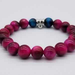 May include: A pink tiger's eye beaded bracelet with a silver clasp and blue tiger's eye end caps.