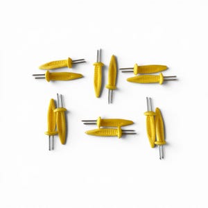 May include: A collection of ten yellow corn-shaped holders, each featuring two sharp metal prongs extending from the base. The handles are molded to resemble the texture of corn on the cob, providing a grip for securing food items during consumption.