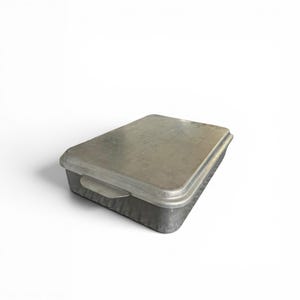 May include: A rectangular metal baking pan with a matching lid. The pan is constructed from a dull, brushed silver-toned metal and features a flat, removable cover that sits securely on top. Small, integrated handles extend from the sides.