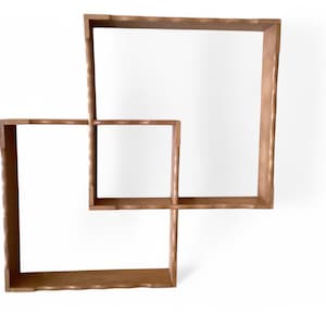 May include: A wooden wall shelf with two square shelves, one stacked on top of the other, with a unique interlocking design.