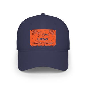 Può includere: Un berretto da baseball blu navy con un design arancione con la scritta "UTSA" e un logo di roadrunner. Il design ha una forma rettangolare decorativa. Il berretto è un classico stile a sei pannelli.