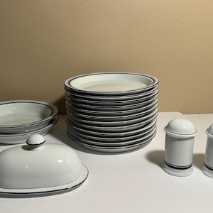 May include: A set of three ceramic mugs with a speckled, matte finish. The mugs are in shades of cream, light gray, and dark gray. Each mug has a simple, minimalist design, perfect for coffee or tea.