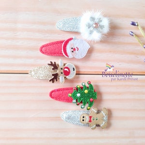 May include: Five Christmas-themed hair clips with glitter and felt. The clips feature a snowflake, Santa Claus, a reindeer, a Christmas tree, and a gingerbread man.