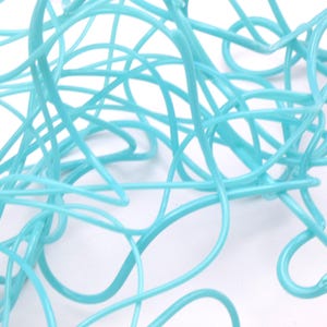 May include: A tangled mass of light blue plastic string. The string is twisted and knotted, creating a complex and abstract pattern.