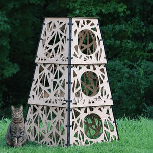 May include: A three-tiered, pyramid-shaped cat tower constructed from light-colored wood panels with intricate, geometric cutouts. Each level features a circular opening and is secured with black hardware at the corners of the structure.
