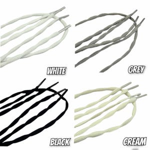 Peut inclure: Ensemble de lacets de chaussures en quatre couleurs : blanc, gris, noir et crème. Chaque lacet est doté d'un embout métallique. Les mots "WHITE", "GREY", "BLACK" et "CREAM" sont imprimés sous chaque couleur.