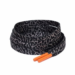 Puede incluir: Cordones de zapatos negros y grises con estampado de leopardo y aglets naranjas.