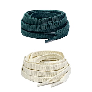 May include: Two pairs of shoelaces, one pair is dark green and the other pair is cream colored.