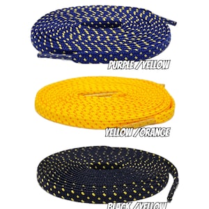 Puede incluir: Tres pares de cordones con un patrón de puntos. Los cordones están enrollados y los colores son morado y amarillo, amarillo y naranja, y negro y amarillo.