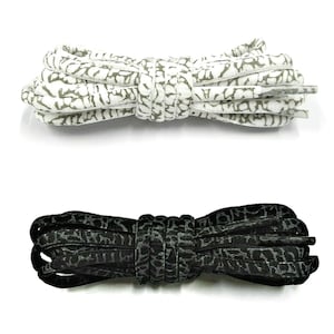 以下が含まれることがあります： 靴紐が2組、1組はグレーの象柄の白い靴紐、もう1組はグレーの象柄の黒い靴紐です。