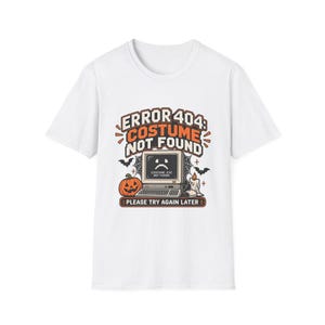Może przedstawiać: Biały t-shirt z krótkim rękawem z nadrukiem graficznym przedstawiającym monitor komputera ze smutną buźką i napisem COSTUME.EXE NOT FOUND. Nad monitorem znajduje się napis ERROR 404: COSTUME NOT FOUND, dynia, nietoperze oraz świeca.