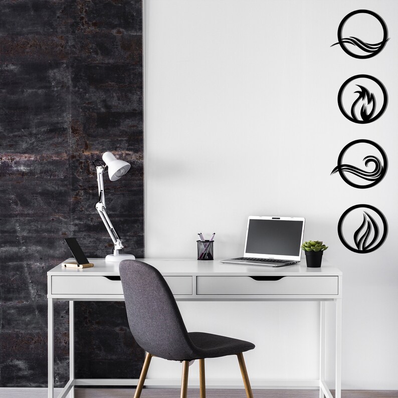 May include: A modern home office setup with a white desk, laptop, and a gray chair. The wall features black circular art pieces representing the elements of nature: water, fire, air, and earth. A white desk lamp and a small potted plant add to the decor.