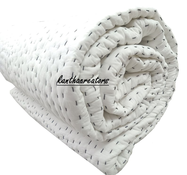 Pu&ograve; includere: Trapunta di cotone bianco con cuciture nere, arrotolata. La trapunta &egrave; realizzata con un design semplice e cucito a mano.