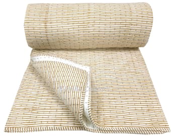 May include: A rolled-up, beige and white quilt with a repeating striped pattern. The quilt is partially unfolded, revealing a white interior and stitched edges. The design features vertical stripes in a warm beige hue against a white background.
