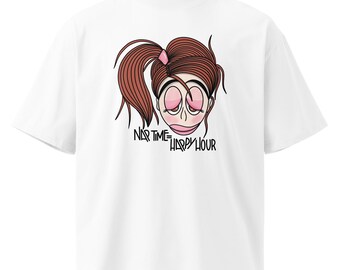 Può includere: Una t-shirt bianca a maniche corte con un'illustrazione grafica di una persona con coda alta e occhi assonnati. Sotto l'illustrazione, il testo nero recita NAP TIME = HAPPY HOUR. Il design utilizza tonalità marroni, rosa e nere.