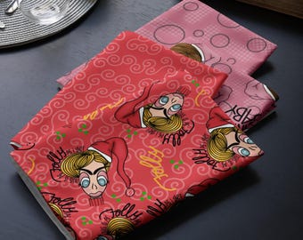 Può includere: Un tessuto rosso piegato con un'illustrazione ripetuta di un personaggio biondo che indossa un cappello da Babbo Natale, con il testo "Jolly as I get" in nero e corsivo giallo, accentuato da piccoli punti verdi e motivi rossi a vortice.