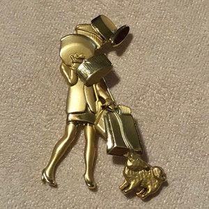 AJC shopping girl with boxes vintage gold brooch