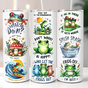 May include: Three white insulated tumblers with whimsical frog illustrations and text. One tumbler features a frog with the text "Whatcha Doin?" and "Do what makes you happy." Another says "Kill 'em with kindness" and "Be Hoppy!" The third says "Hang in there" and "Frog Off."