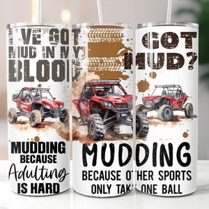 Op de afbeelding: Drie witte ge&iuml;soleerde bekers met zwarte tekst en illustraties van rode terreinwagens. De tekst op de bekers luidt "I'VE GOT MUD IN MY BLOOD", "MUDDING BECAUSE Adulting IS HARD", "GOT MUD?" en "MUDDING BECAUSE OTHER SPORTS ONLY TAKE ONE BALL".