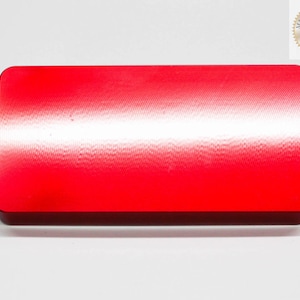 Puede incluir: Un bloque rectangular rojo con una superficie lisa y ligeramente texturizada. El bloque tiene un degradado sutil de un rojo m&aacute;s claro a un rojo m&aacute;s oscuro.