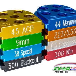 May include: A set of six different colored metal reloading blocks, each with a different caliber designation. The calibers are 45 ACP, 9mm, 38 Special, 300 Blackout, 44 Magnum, 223/5.56, 6.5 Creedmoor, and 308 Win. The blocks are stacked on top of each other, with the largest block at the bottom and the smallest block at the top. The blocks are made of a durable metal and are designed to be used with a reloading press. The blocks are made in the USA with pride.