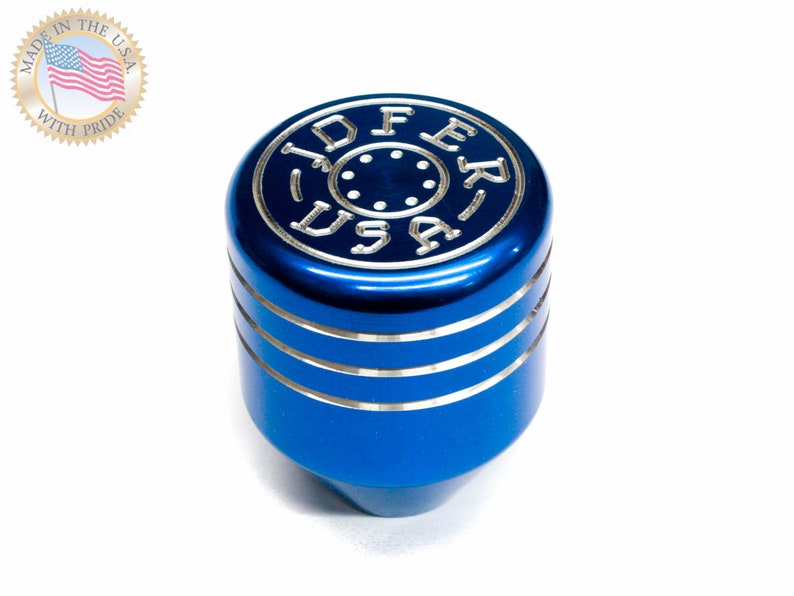 Puede incluir: Pomo de cambio de marchas de aluminio azul con detalles plateados y las palabras "JDFER USA" grabadas en la parte superior.