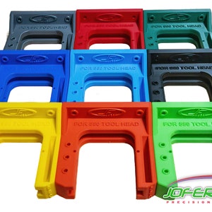 May include: Nine different colored plastic tool holders for a BEO tool head. The holders are stacked in three rows of three. The holders are labeled "FOR BEO TOOL HEAD".