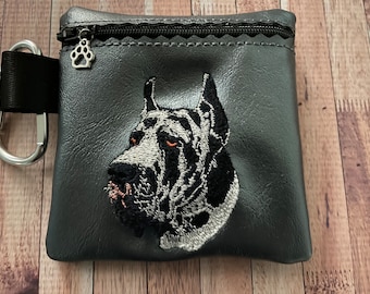 May include: A black zippered pouch with a paw print zipper pull. The pouch has an embroidered image of a Great Dane's head.