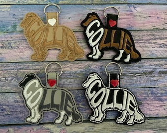 May include: Four different colored keychains featuring a silhouette of a Collie dog with the word "Collie" spelled out within the silhouette. Each keychain has a small heart charm attached.