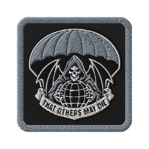 May include: Embroidered patch featuring a grim reaper figure with a skull face, holding a globe, under a parachute. The text "THAT OTHERS MAY DIE" is displayed on a banner. The patch has a black background with a denim-like border.