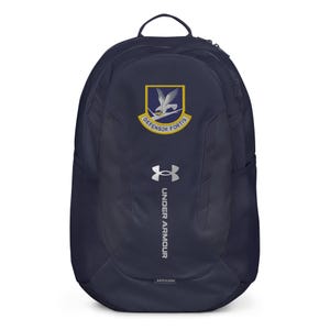 May include: Navy blue backpack with the Under Armour logo and a patch featuring a bird and the words "Defensor Fortis." The backpack has a top handle, side pockets, and a front pocket. The backpack is made of a durable material.