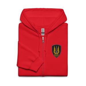 May include: A bright red zip-up hoodie featuring a hood with drawstrings and a full-length front zipper. On the left chest, there is a black shield-shaped patch displaying a silver sword, yellow wings, and the text OSONS in black on a yellow banner.