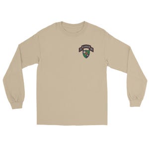 May include: A long-sleeve, tan-colored shirt. The shirt features a patch on the upper left chest with the text "75 RANGER REGT" in a black banner. The patch has a green, white, and blue design.