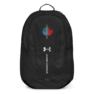 May include: Black Under Armour backpack with a logo featuring a globe, a red maple leaf, and a silver sword. The backpack has a top handle, side mesh pockets, and the Under Armour logo in silver.