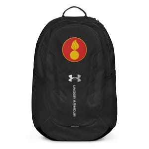 以下が含まれることがあります： 赤と黄色のエンブレムが付いた黒いUnder Armourバックパック。バックパックには上部のハンドル、サイドメッシュポケット、シルバーのUnder Armourロゴが付いています。バックパックは湾曲した形状で、Stormラベルが付いています。