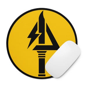 Könnte beinhalten: Rundes gelbes Mauspad mit einer schwarzen Grafik eines Blitzes und eines stilisierten Dreiecks. Eine weiße Computermaus befindet sich auf der rechten Seite des Mauspads.