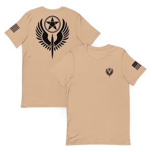 May include: Tan t-shirts with black graphic designs. One shirt displays a large emblem on the back with a star, wings, and a dagger. The other shirt has a smaller version of the emblem on the front. Both shirts have an American flag on the sleeve.