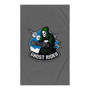 Op de afbeelding: Grijze vlag met een afbeelding van een Grim Reaper in een groene capuchonmantel, die een machinegeweer vasthoudt. Het ontwerp bevat een blauw-witte wolkenachtergrond met de tekst "GHOST RIDER" in een witte, gebogen letter.