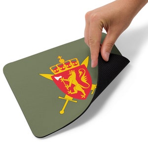 May include: A green mouse pad with a yellow lion and a red shield. The shield has a yellow crown and a yellow axe. The mouse pad has a black rubber backing.