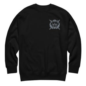 May include: A black long-sleeve sweatshirt featuring a gray graphic on the upper left chest. The graphic depicts a diver wearing a mask and snorkel, positioned in front of two crossed knives, creating a detailed emblem on the solid black fabric.