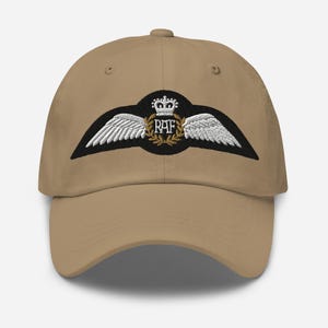 May include: A khaki baseball cap with an embroidered Royal Air Force (RAF) wing patch. The patch features a crown, the letters "RAF", and a laurel wreath.