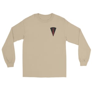 May include: A long-sleeve crew neck t-shirt in a solid tan color. On the upper left chest, there is a small triangular patch graphic featuring a black background with a centered, vertical red dagger icon pointing downward.