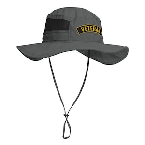 May include: A gray, wide-brimmed sun hat with a black mesh panel and a yellow patch that says "Veteran".