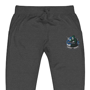 May include: Dark gray sweatpants with a drawstring waist and pockets. A patch on the left leg features a grim reaper riding a motorcycle with the text "GHOST RIDER" in a circular design.