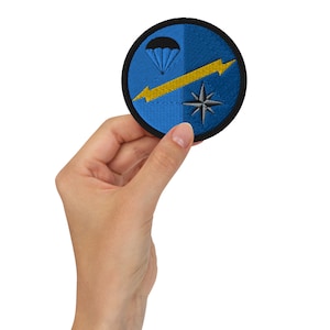 以下が含まれることがあります： パラシュート、黄色の稲妻、風車を描いた青と黒の刺繍パッチ