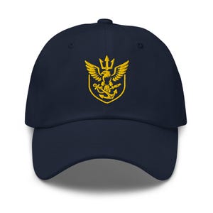 May include: Navy blue baseball cap with a gold embroidered emblem featuring an eagle, trident, and anchor. The cap has a curved brim and a six-panel design. A classic, adjustable hat.