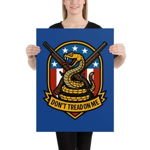 May include: Poster featuring a coiled yellow snake with a menacing expression, set against a shield design with crossed rifles and stars. The text "DON'T TREAD ON ME" is prominently displayed on a blue background.