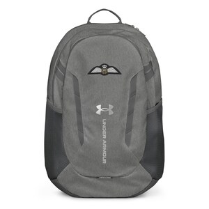 May include: A gray Under Armour backpack with a silver logo and a patch with a winged emblem. The backpack has a mesh pocket on the side and a zippered pocket on the front.