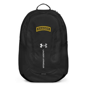 May include: Black Under Armour backpack with the word "RANGER" in a yellow rectangle at the top. The Under Armour logo and text are in silver. The backpack has a top handle and side mesh pockets.